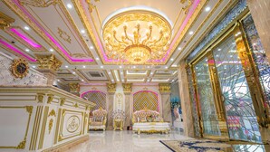 Une pièce somptueuse, ornée d’un magnifique lustre, d’un plafond richement décoré et de meubles luxueux.