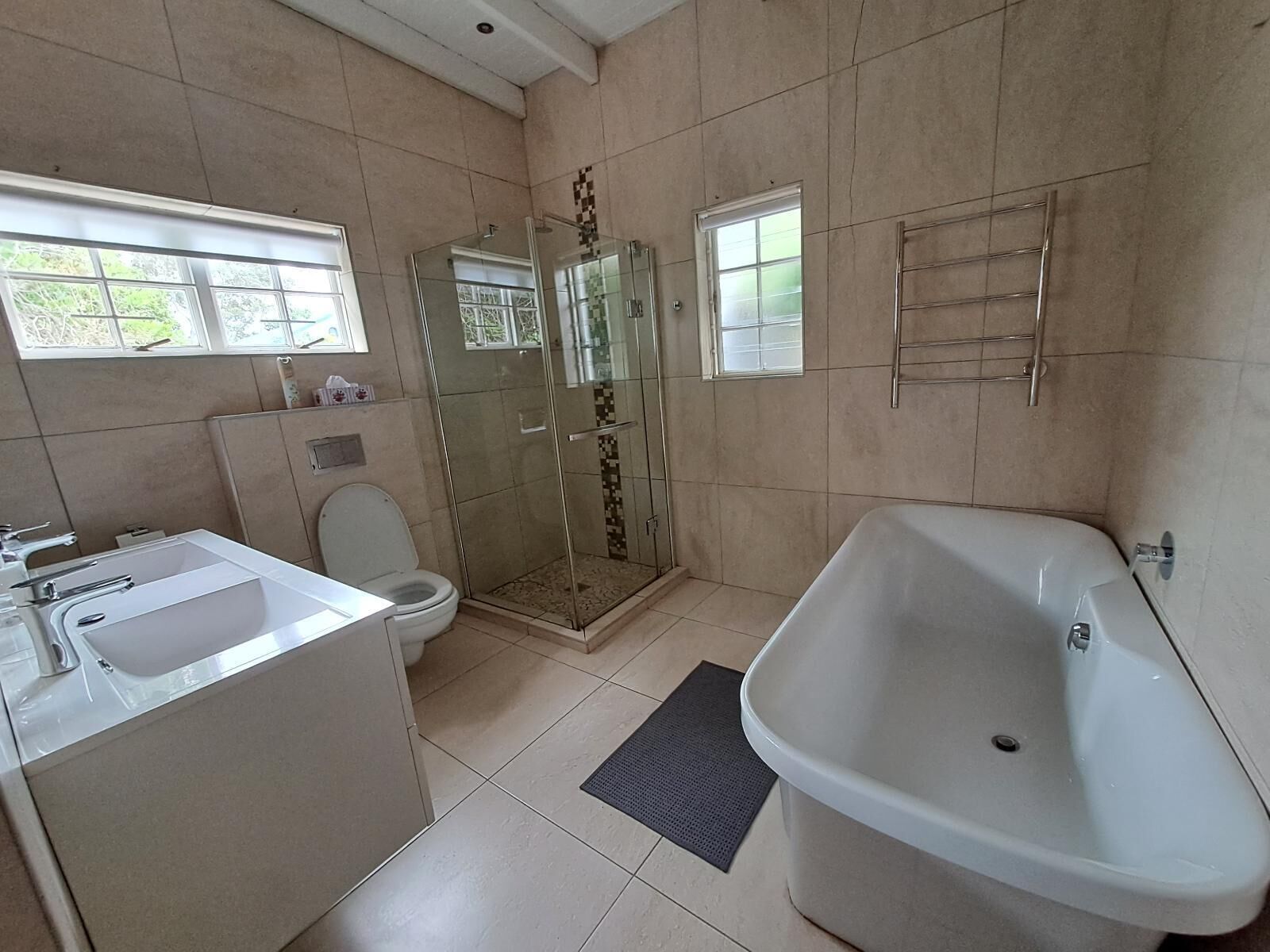 A bathroom with a bathtub, toilet, and glass-enclosed shower.