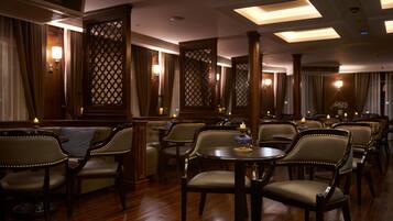 A restaurant with wooden furniture, chandeliers, and a warm ambiance.