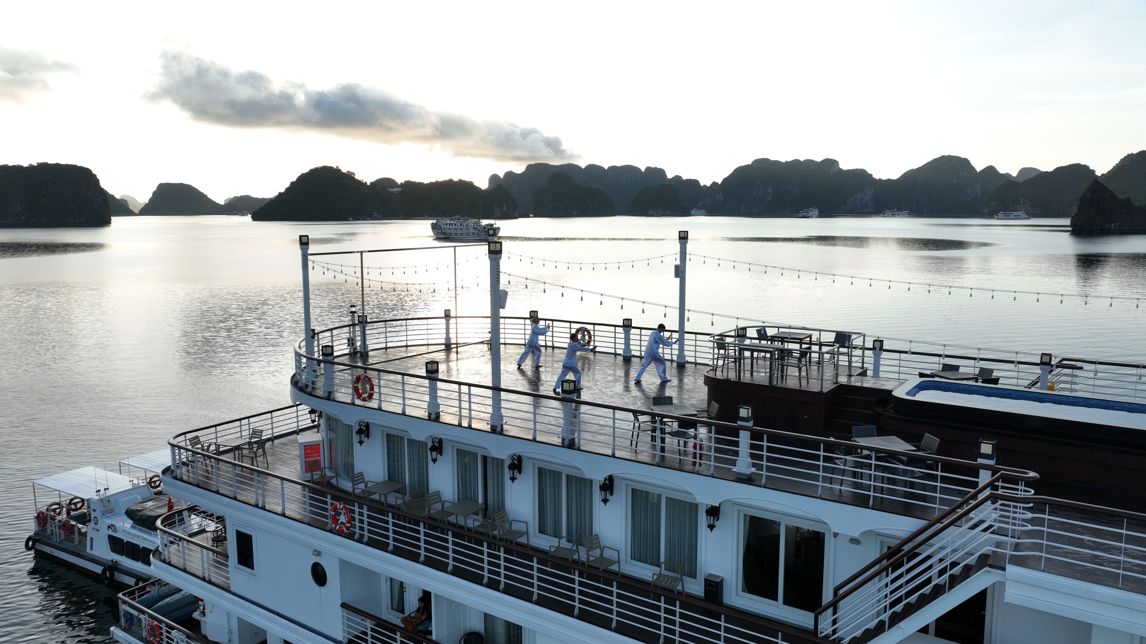 A ferry with a deck area featuring outdoor seating, a lifebuoy, and a railing.