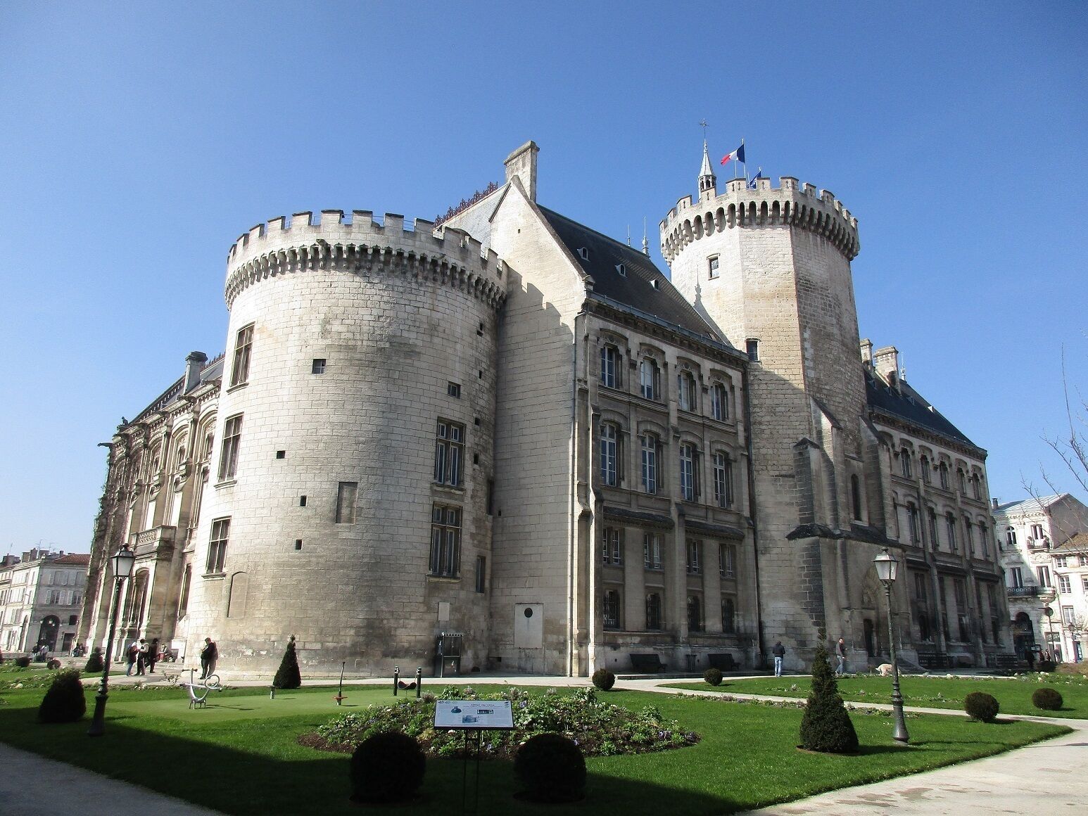A historic stone building with a round tower and a central courtyard.