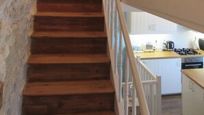 A wooden staircase with white railings leading to a room with a turquoise wall and a white ceiling. - 4 - Star Holiday Home on the Charente River. (Bourg-Charente)