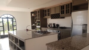A modern kitchen with granite countertops, stainless steel appliances, and a large island. - Villa l "Ambre d'Essaouira (Essaouira)