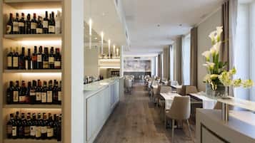 Un moderno vestíbulo de hotel con un bar de vinos, zona de comedor y vistas de la ciudad.