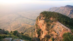 A mountainous landscape with a clear path along the ridge.