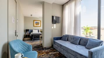 Suite Junior, terrasse, vue ville | Coin séjour | Télévision à écran plat