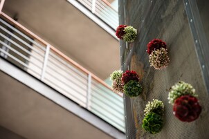 Vista del exterior de un edificio con una malla y una barandilla metálica.