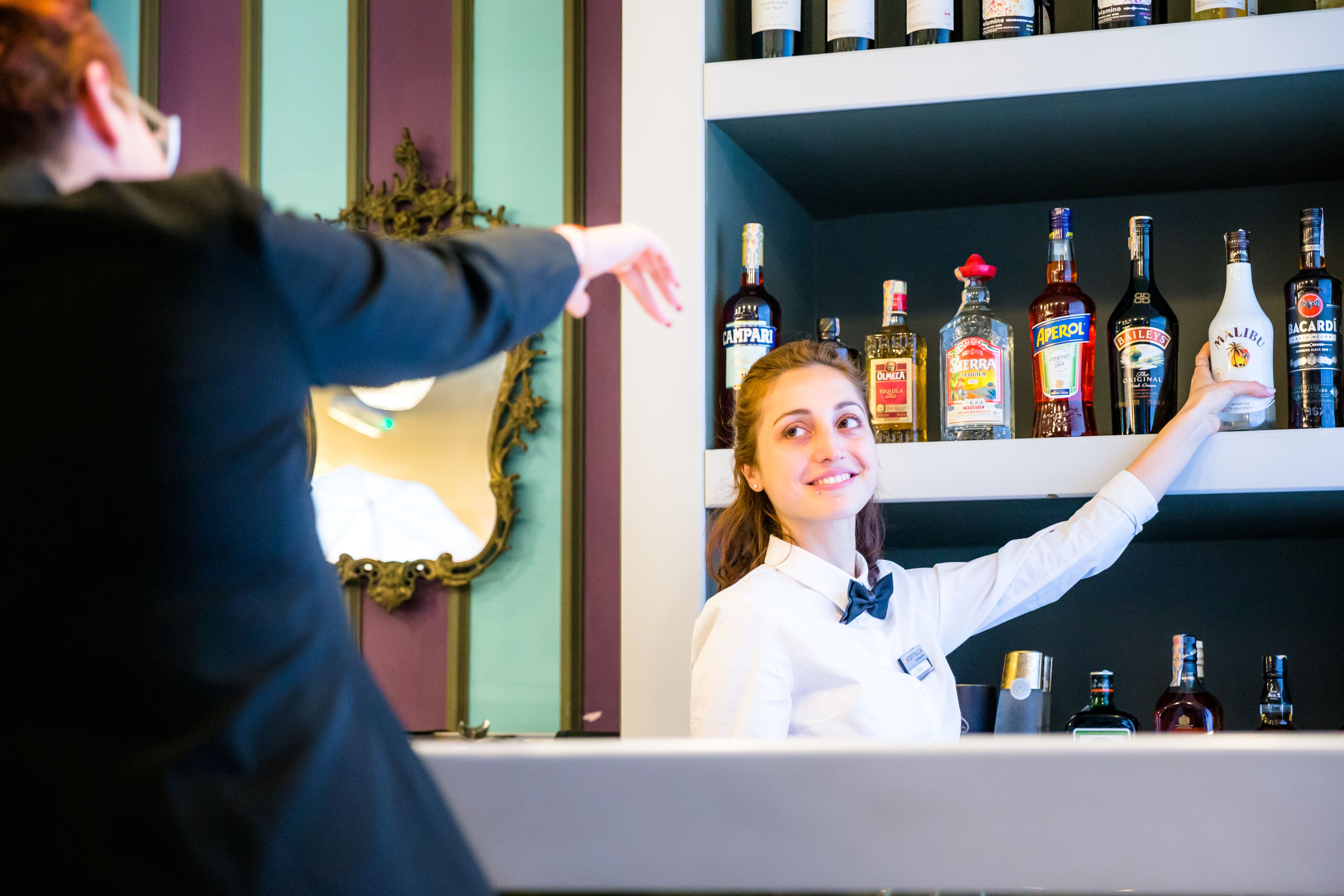 A bar with shelves stocked with various liquor bottles.