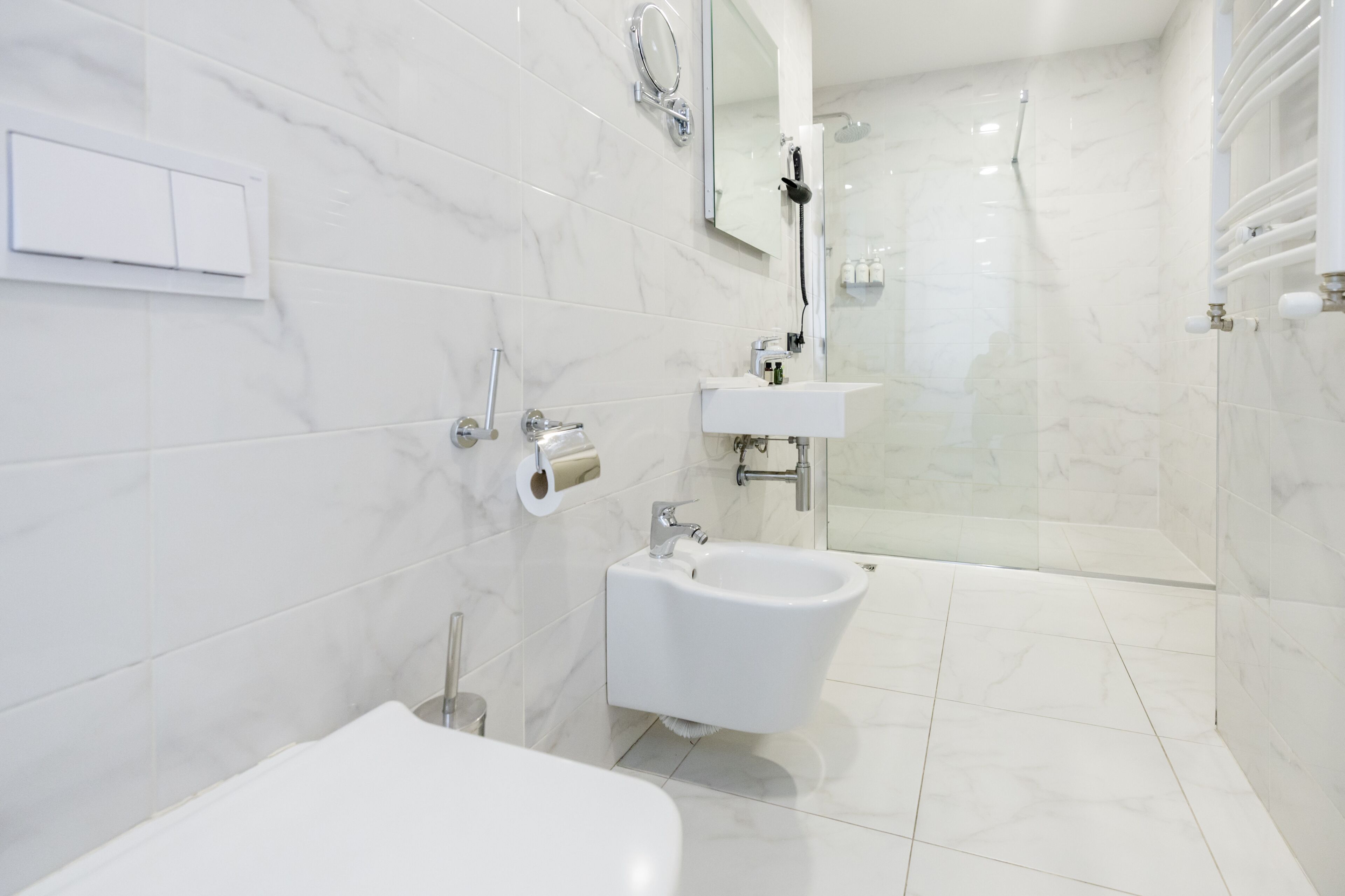 A modern bathroom with a toilet, bidet, and shower.