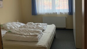 A small, single-bed room with a window, a radiator, and a door. - Quiet and yet centrally located in Binz (Binz)