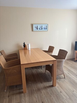 A conference table with four wicker chairs, a framed picture on the wall, and a roll of paper towels on the table. - Quiet and yet centrally located in Binz (Binz)