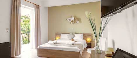 A hotel room with a bed, bedside lamps, a TV, a desk with a tablet, and a view of the outdoors.