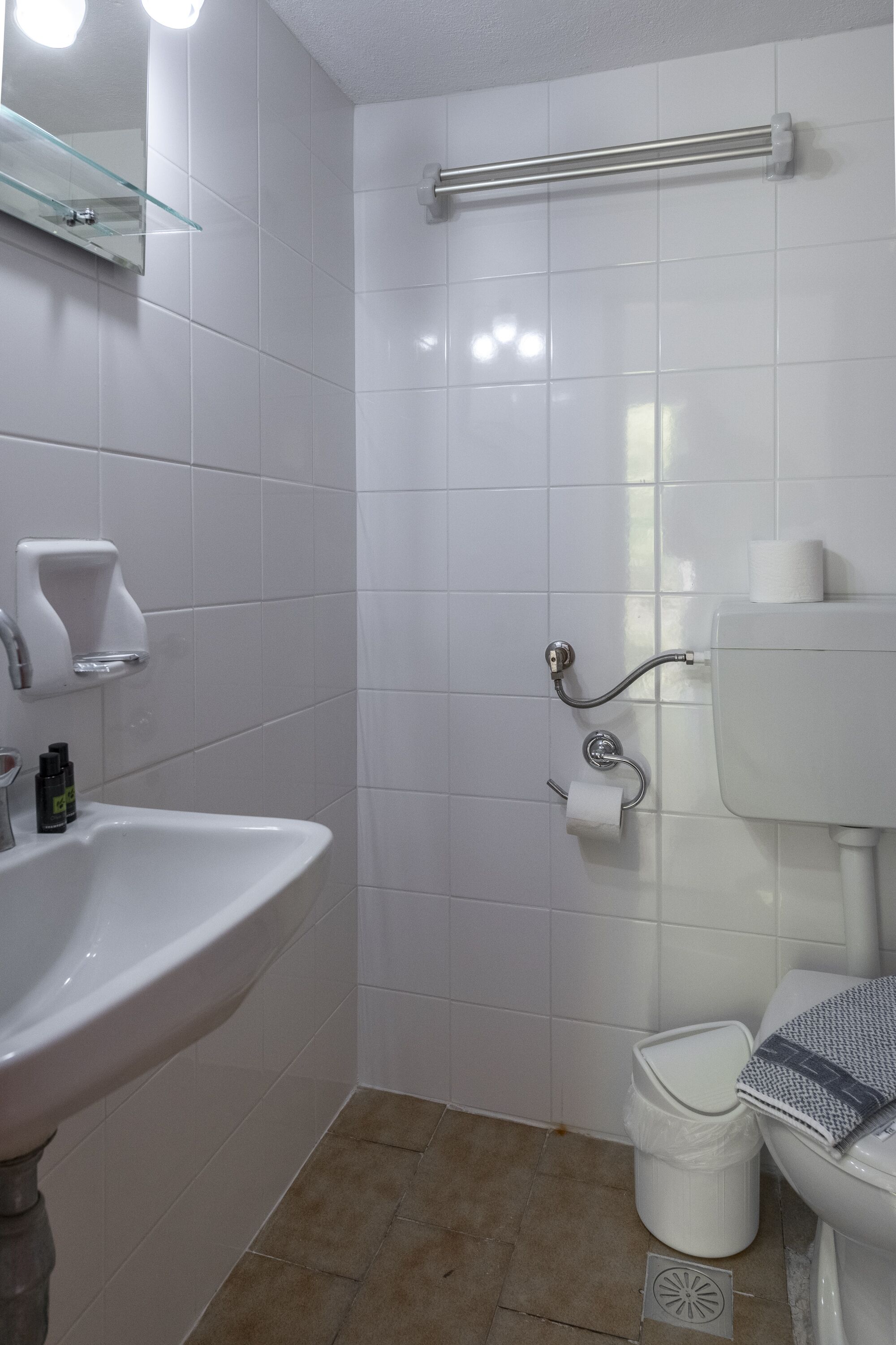 A bathroom with a sink, toilet, and shower area.
