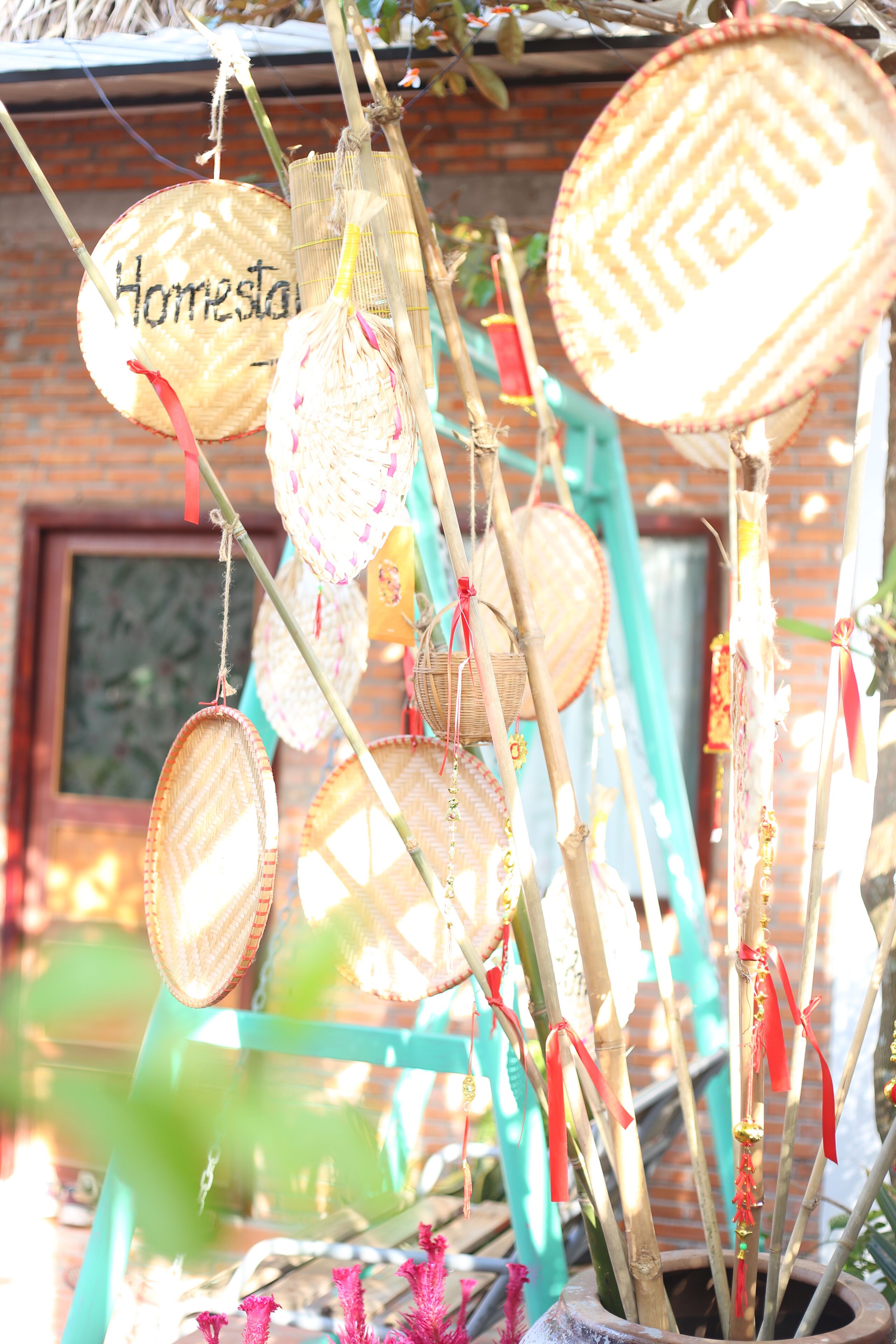 A collection of woven baskets hanging from a structure, with one basket labeled "Homestay".