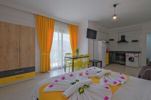 Una habitación de hotel con cama, comedor y kitchenette.
