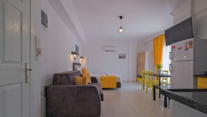 A modern apartment with a living area, kitchenette, and dining space. - F48 Homes (Fethiye)
