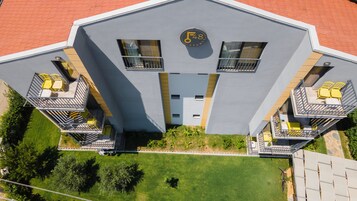 A modern building with balconies, a central entrance, and a sign indicating 48 apartments.