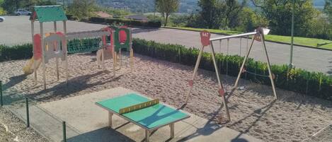 A playground with a swing set and a small climbing structure.