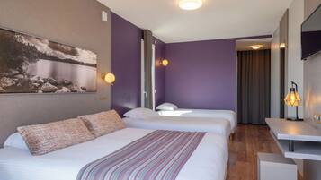 Une chambre d’hôtel avec deux lits, un bureau et un tableau au mur.