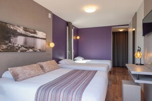 Una habitación de hotel con dos camas, un escritorio y un cuadro en la pared.