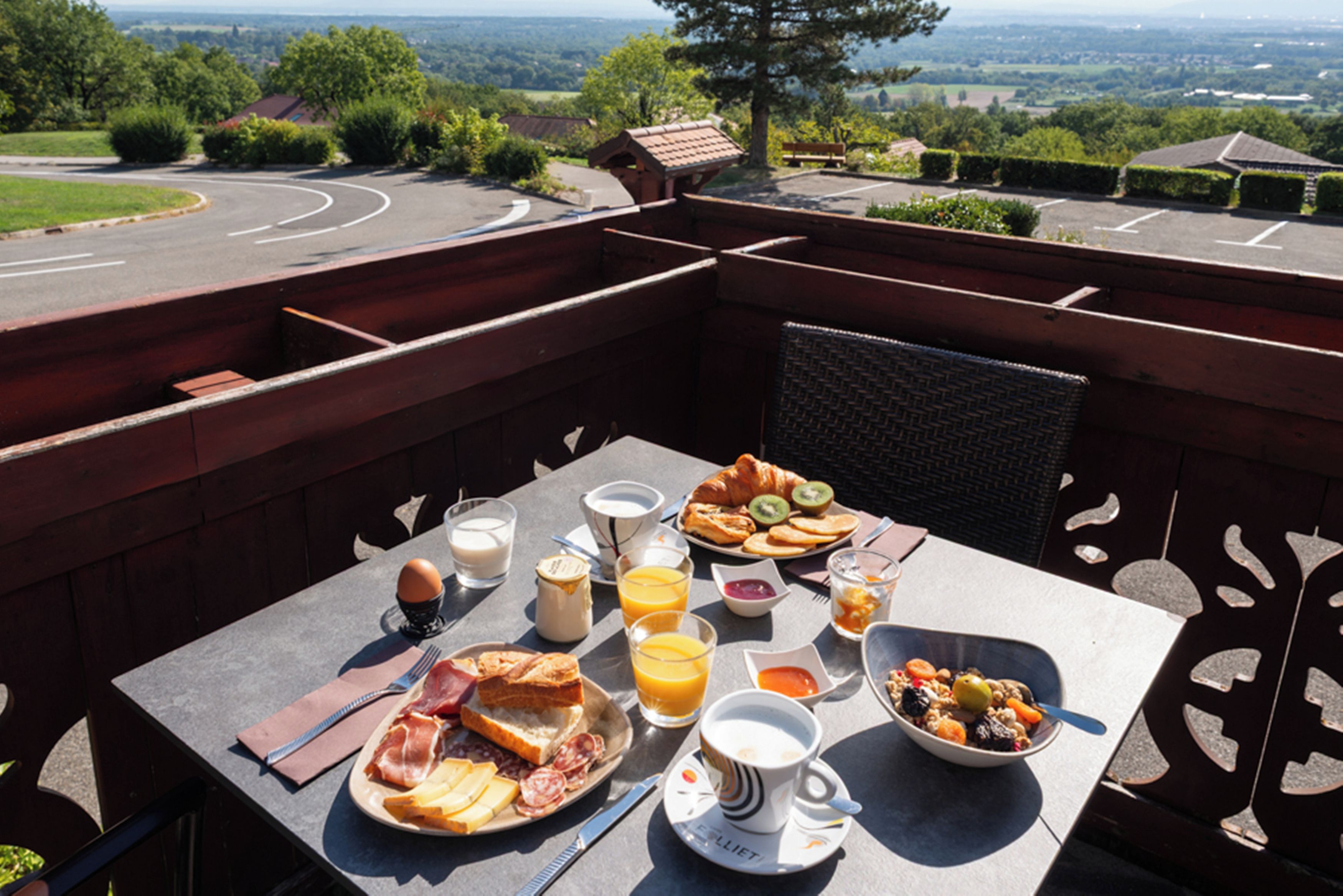 Ein Frühstückstisch mit verschiedenen Speisen und Getränken, mit Blick auf eine schöne Landschaft.