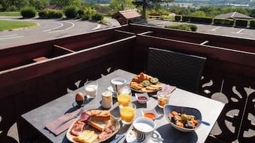 Ein Frühstückstisch mit verschiedenen Speisen und Getränken, mit Blick auf eine schöne Landschaft.