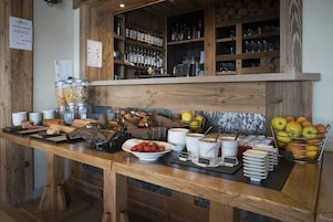 Um buffet de café da manhã com diversas opções de alimentos e bebidas.