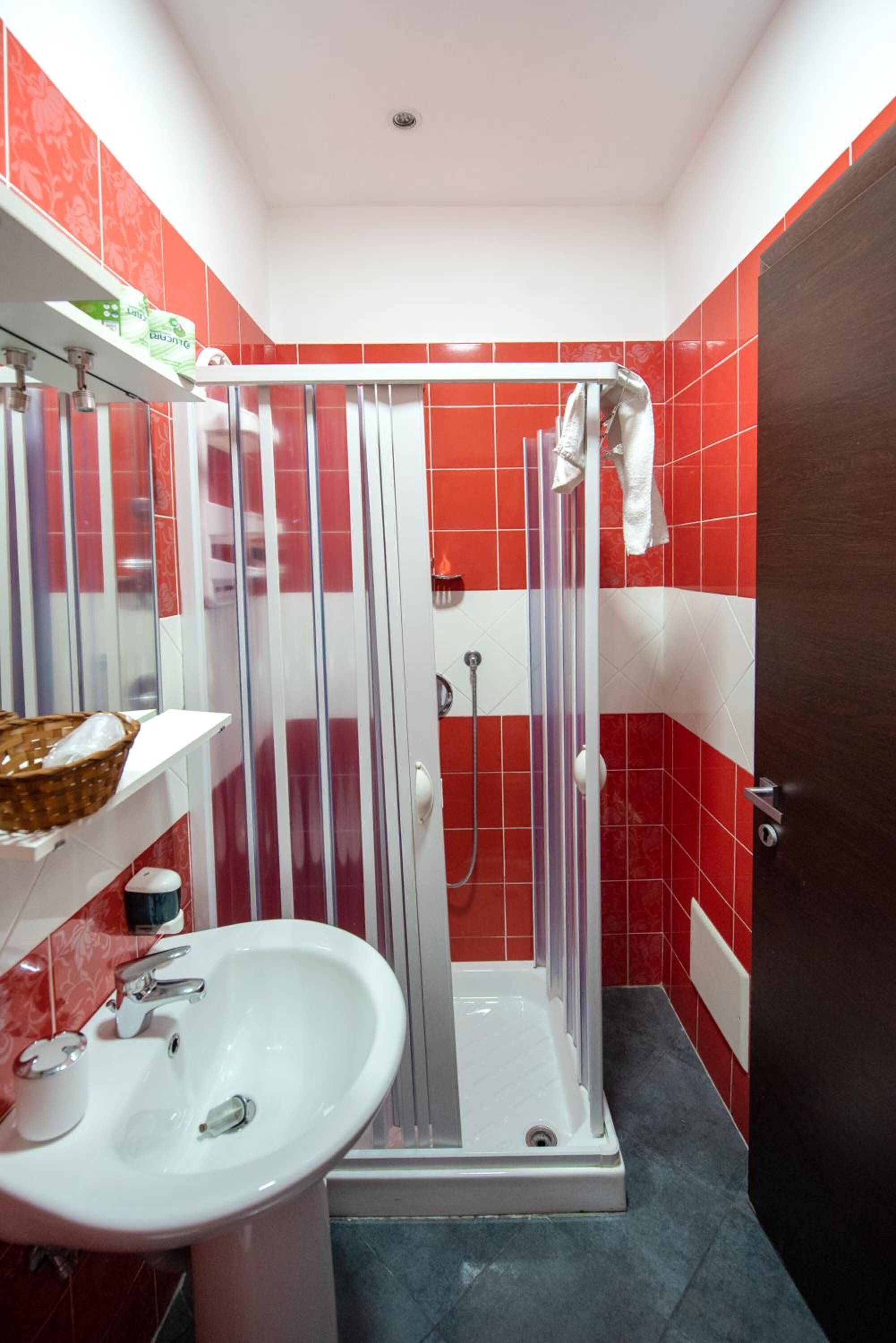 Un baño con ducha, lavamanos y espejo.