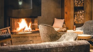 Un salon chaleureux avec une cheminée, des sièges confortables et un plancher en bois.