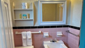 Kylpyhuoneessa on wc, pesuallas ja peili. Pesualtaan yläpuolella on hyllyjä, joilla on hygieniatuotteita.