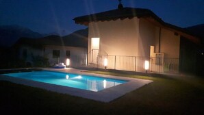 A swimming pool with a house in the background.