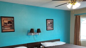 Ein Hotelzimmer mit zwei Betten, einem Deckenventilator und zwei Wandleuchten.