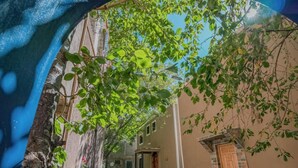 A narrow street with a building on the right and a tree with green leaves in the foreground. - Mount Toubkal Lodge (Asni)