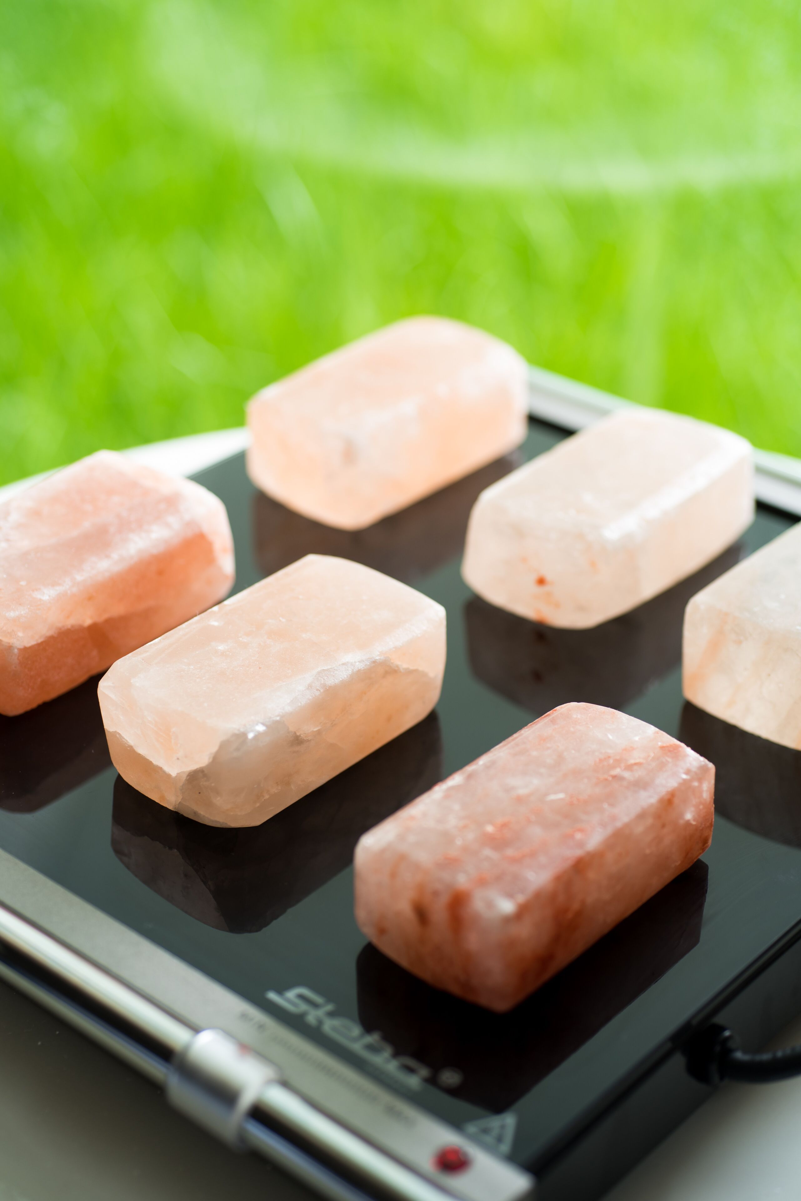 Una tableta mostrando una cuadrícula de cristales rosados sobre una superficie reflectante.