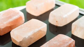 Una tableta mostrando una cuadrícula de cristales rosados sobre una superficie reflectante.