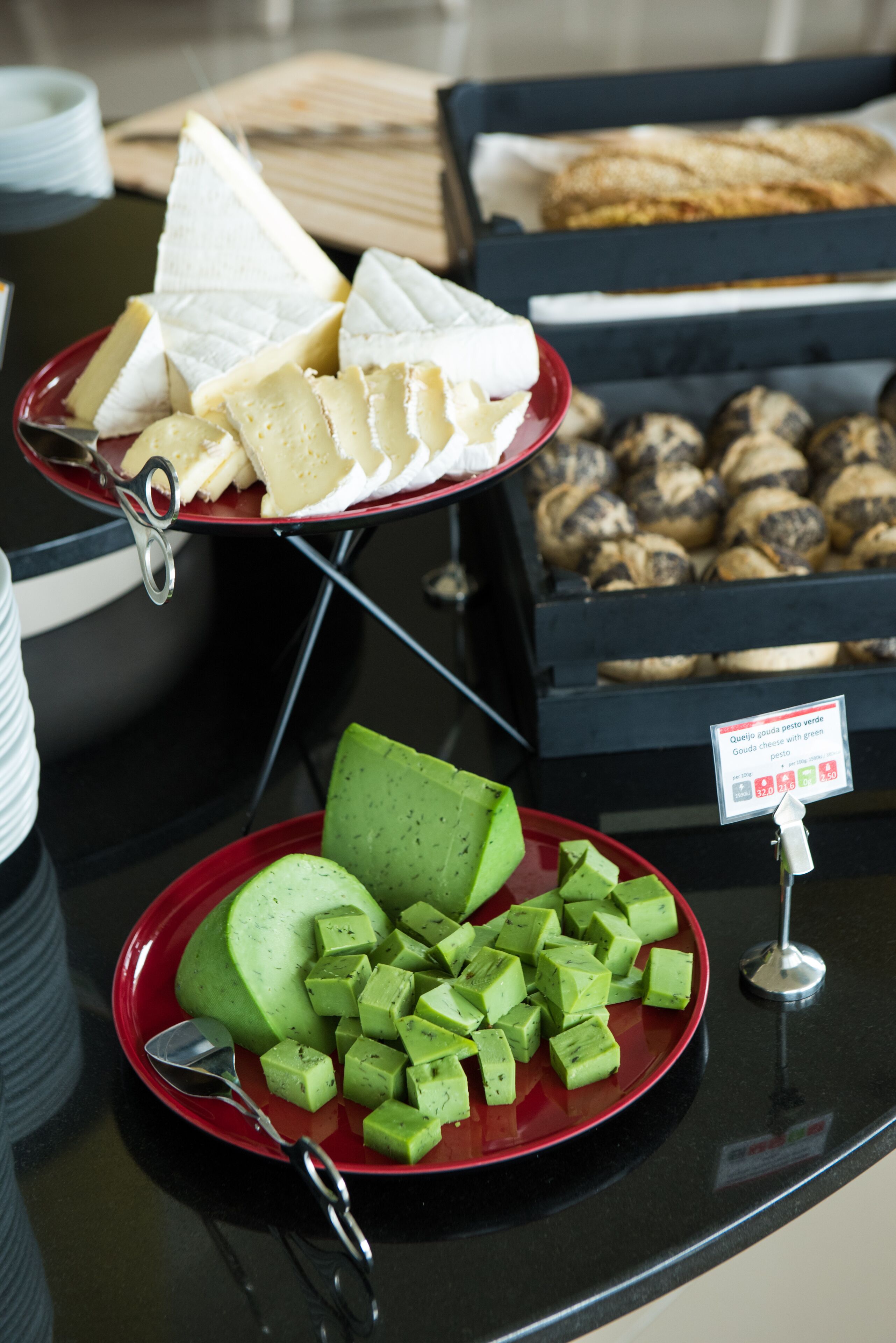A buffet table with various food items including cheese, green cheese cubes, and pastries.