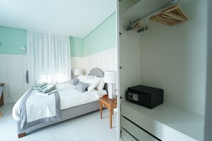 Une chambre à coucher avec un lit, des tables de chevet, une lampe et une radio.