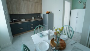 Een moderne keuken met houten kastjes, een koelkast en een eettafel gedekt voor twee personen.