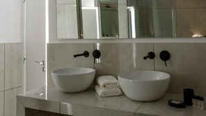 A modern bathroom with two large white vessel sinks, a mirror above, and a glass shower enclosure. - Acropolis Grand Apartment (Athens)