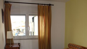 Una habitación con dos camas, un escritorio con lámpara y una ventana con cortinas.