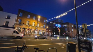 A street view at night with a building featuring a sign that reads "Eccles Townhouse."