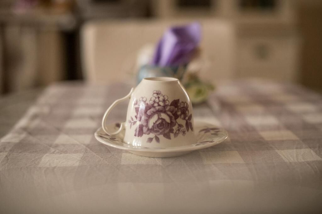 Eine Tasse mit floralem Muster auf einer Tischdecke.