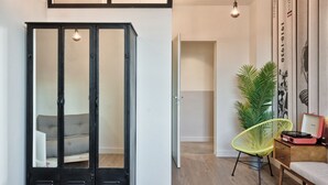 Een kamer met een kast, een stoel, een bed en een plant.