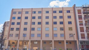 A multi-story building with a uniform facade, numerous windows, and a flat roof. - Sturzo 44 (Palermo)