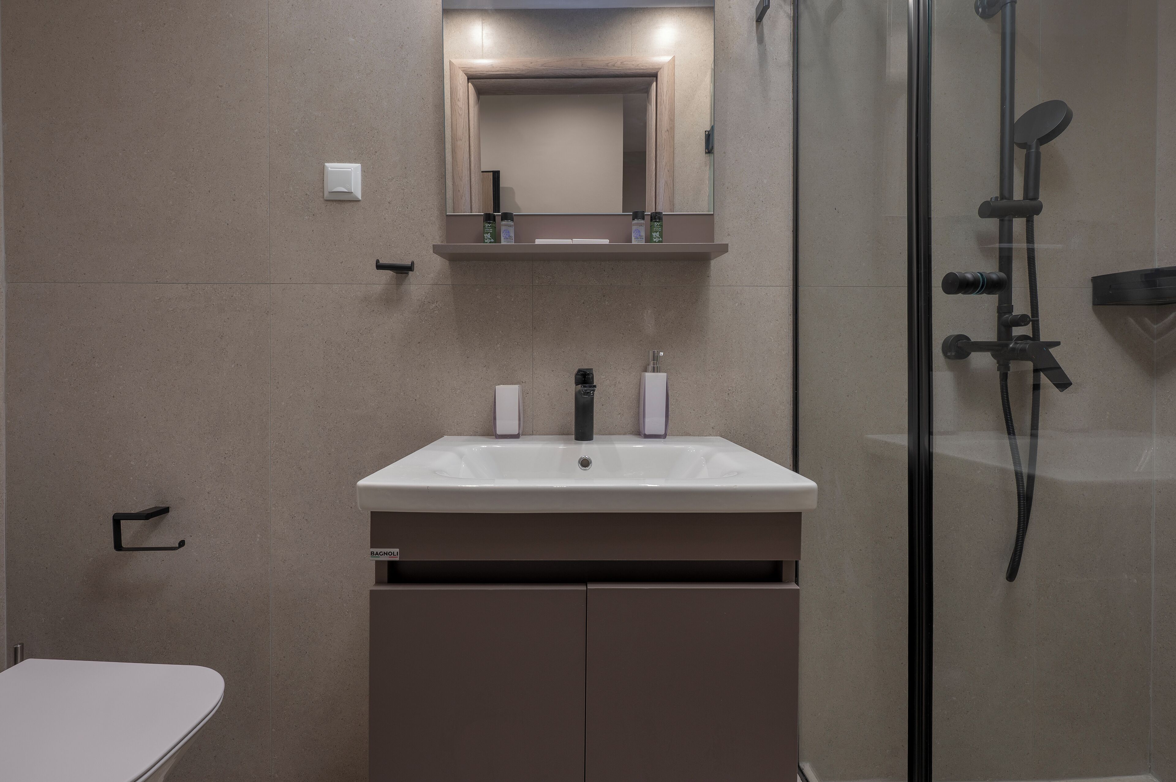 Ein modernes Badezimmer mit einem weißen Waschbecken, Spiegel und Dusche.