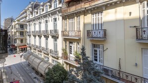 Um edifício com várias andares, varandas, janelas amplas e vista para a rua.