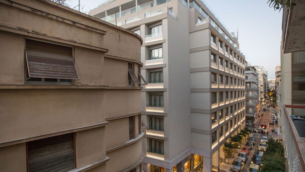 A multi-story building with a modern architectural design, featuring balconies and large windows. - Cozy Apartment in Syntagma - Plaka by GHH (Athens)