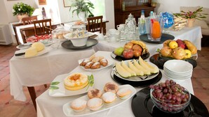 A breakfast buffet with various fruits, pastries, and beverages. - S'Arenada Hotel (Villasimius)