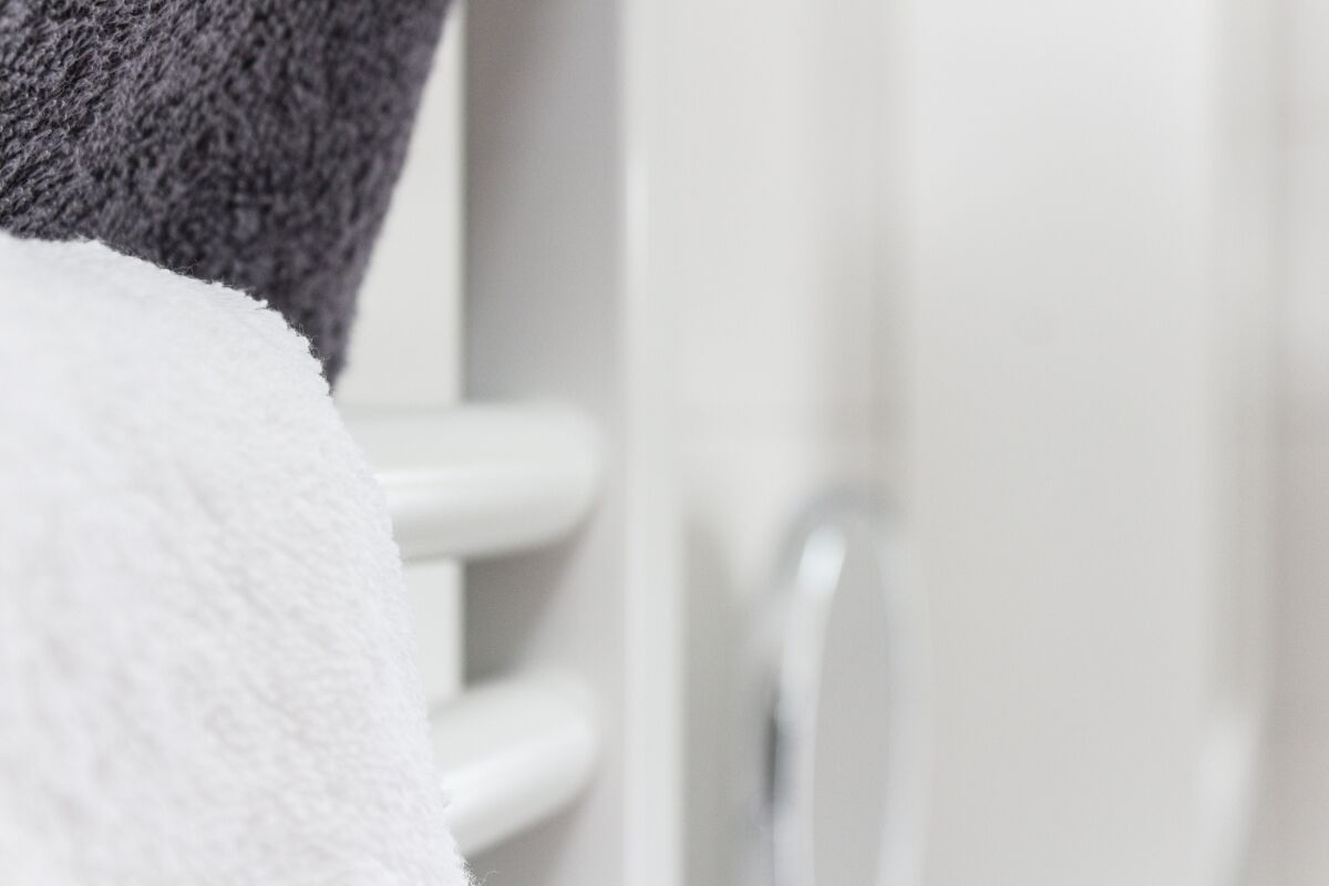 A white towel on a white radiator in a bathroom.