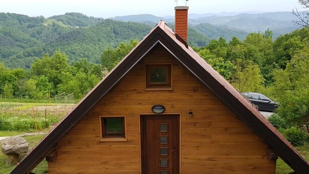 A wooden cabin with a stone foundation, a pitched roof, and a small window. - Relaxing Cottage Donacka Gora (Rogatec)
